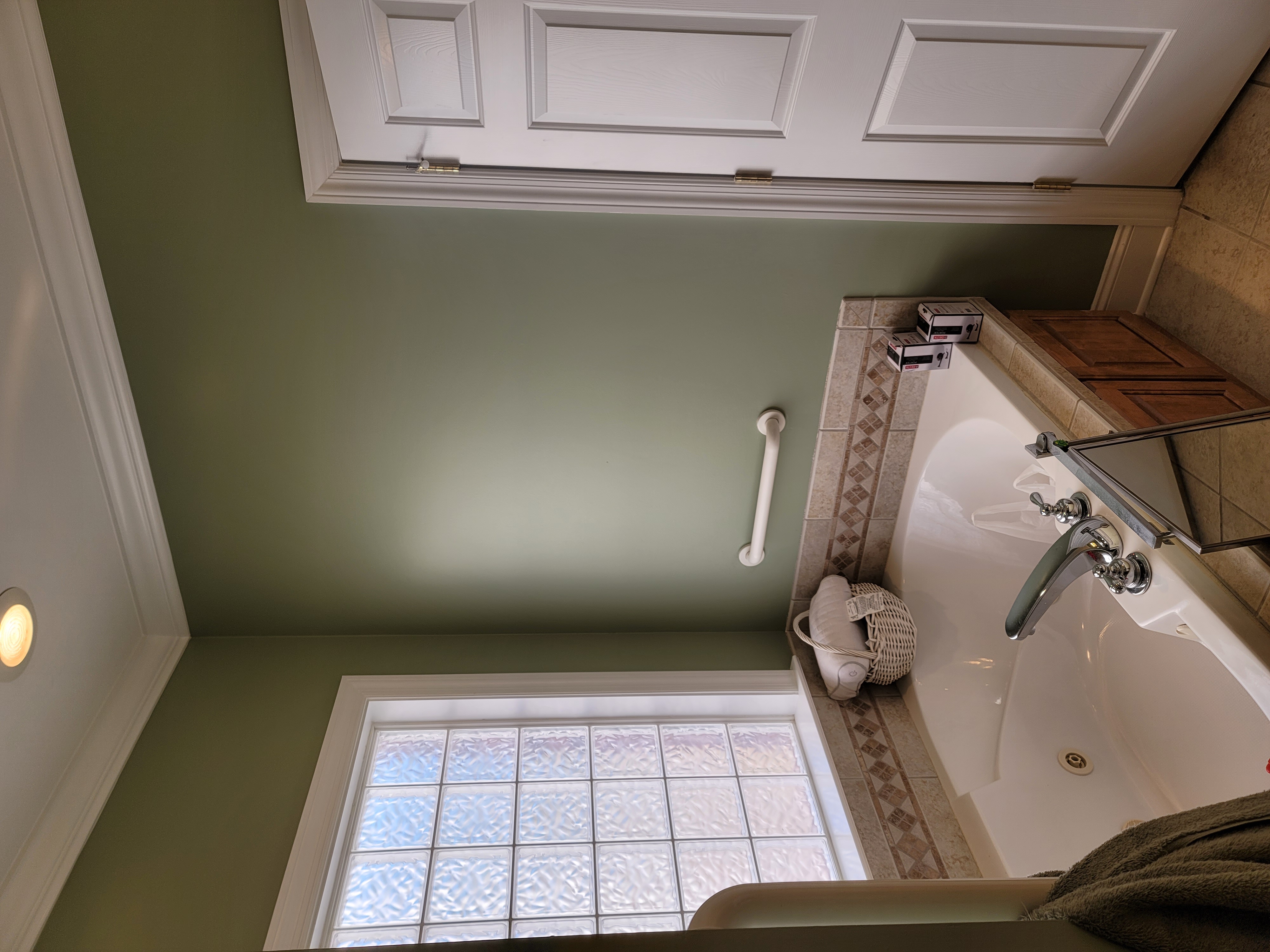 Corner soaking tub with green accent walls