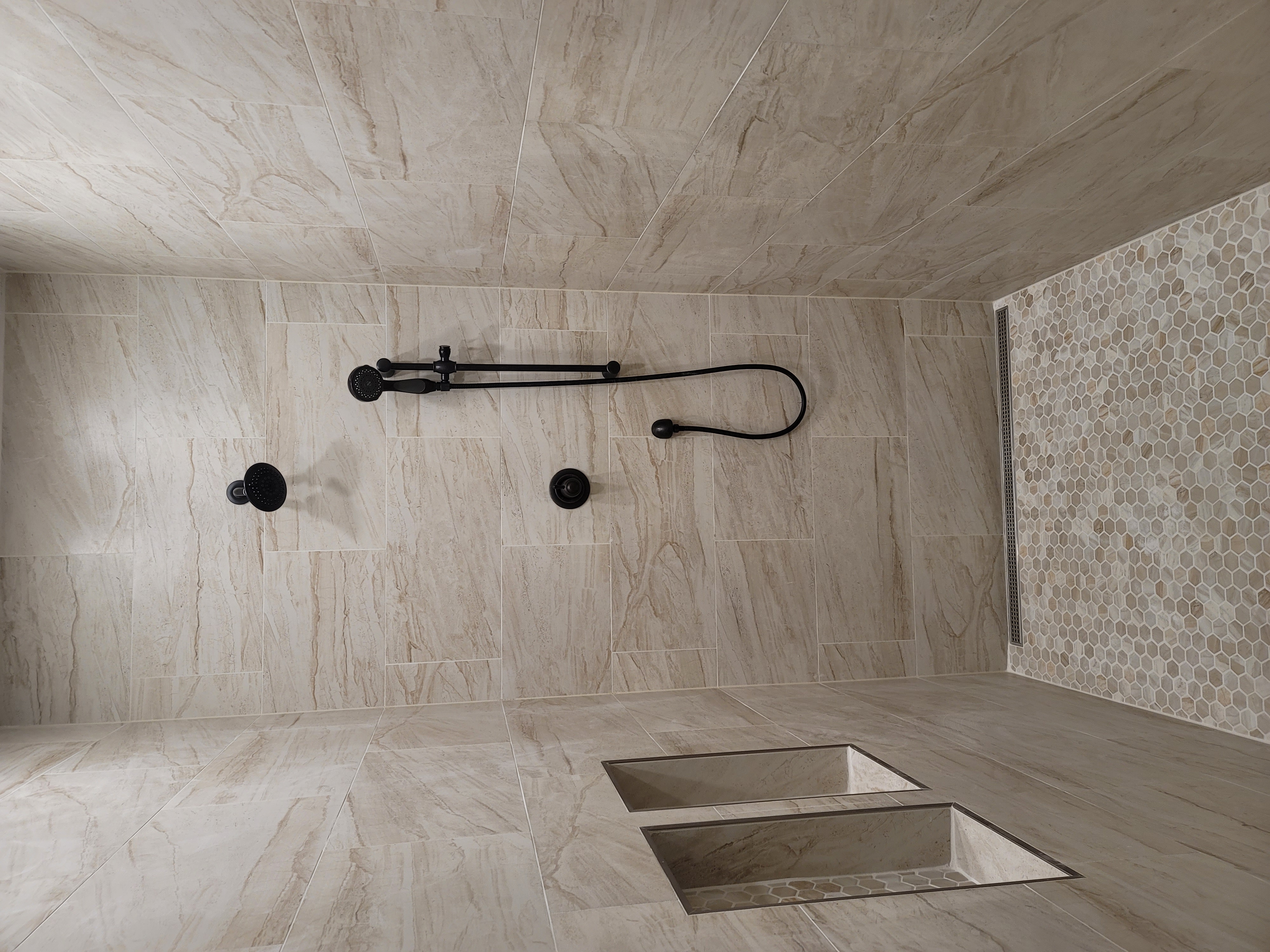 Walk-in shower with matte black fixtures and wall niches