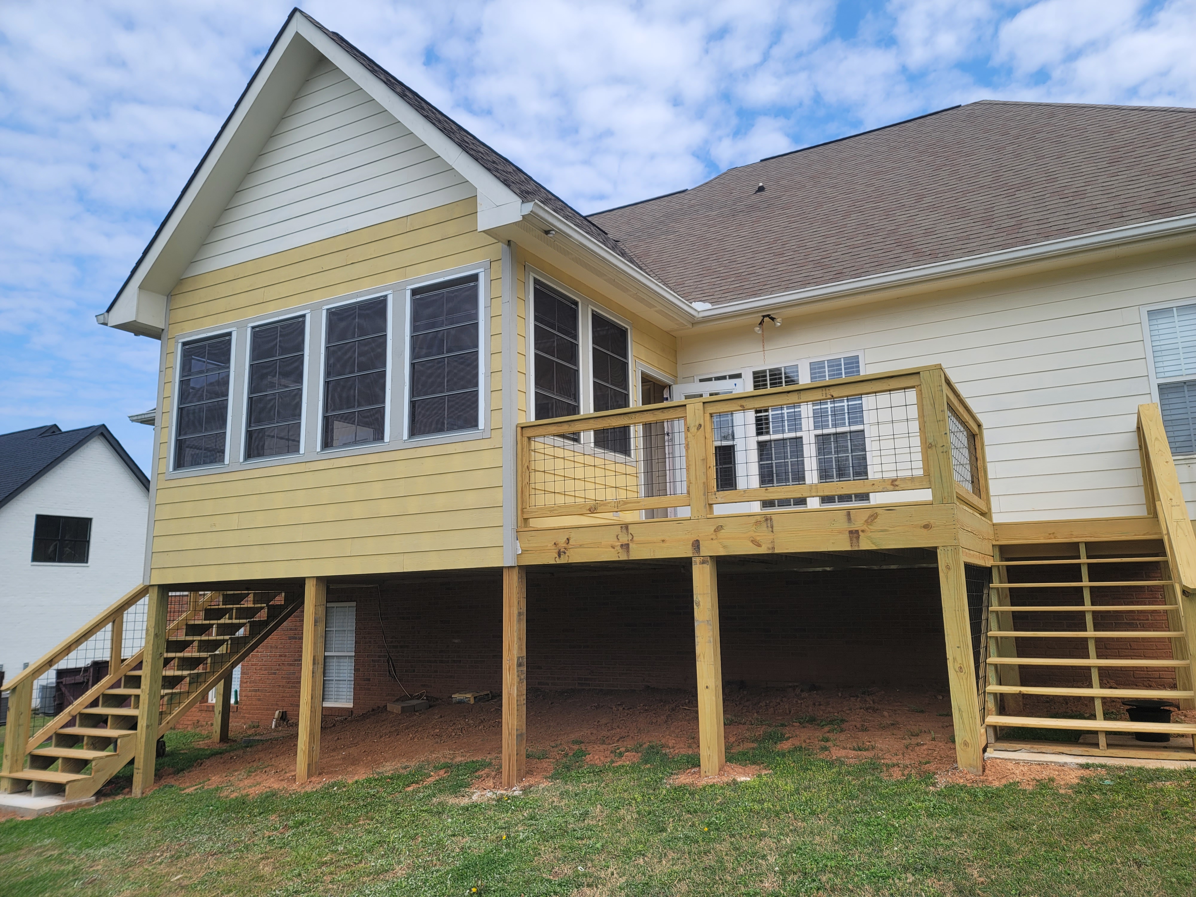 Yellow sunroom exterior with wood deck